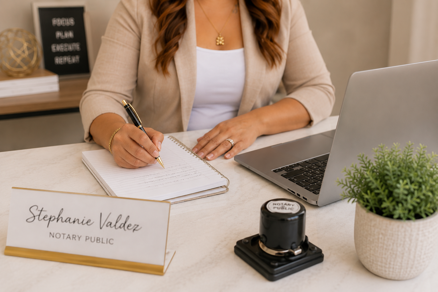 Notary journal, pen, and laptop on a desk during a signing appointment